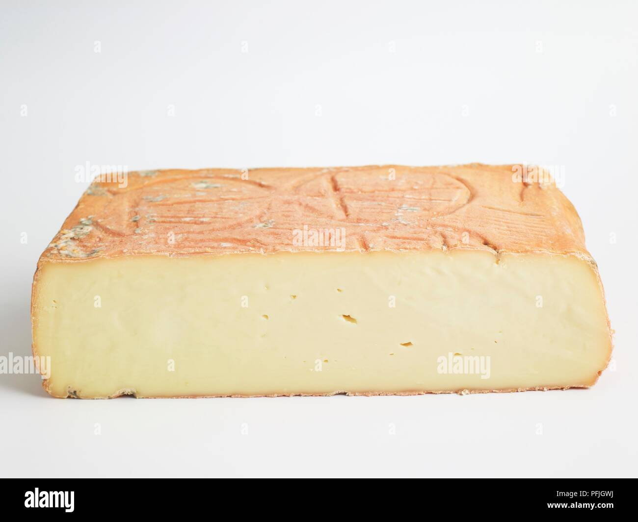 Square of Italian Taleggio PDO cow's milk cheese showing mouldripened