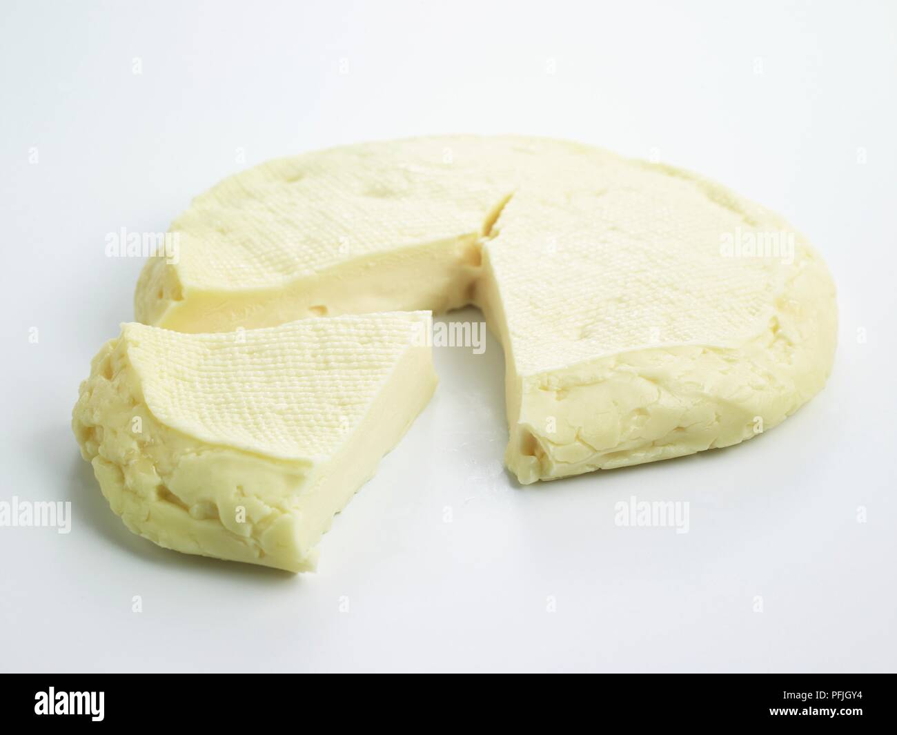 Flat disc and slice of ripe Spanish Pasiego de las Garmillas cow's milk cheese Stock Photo