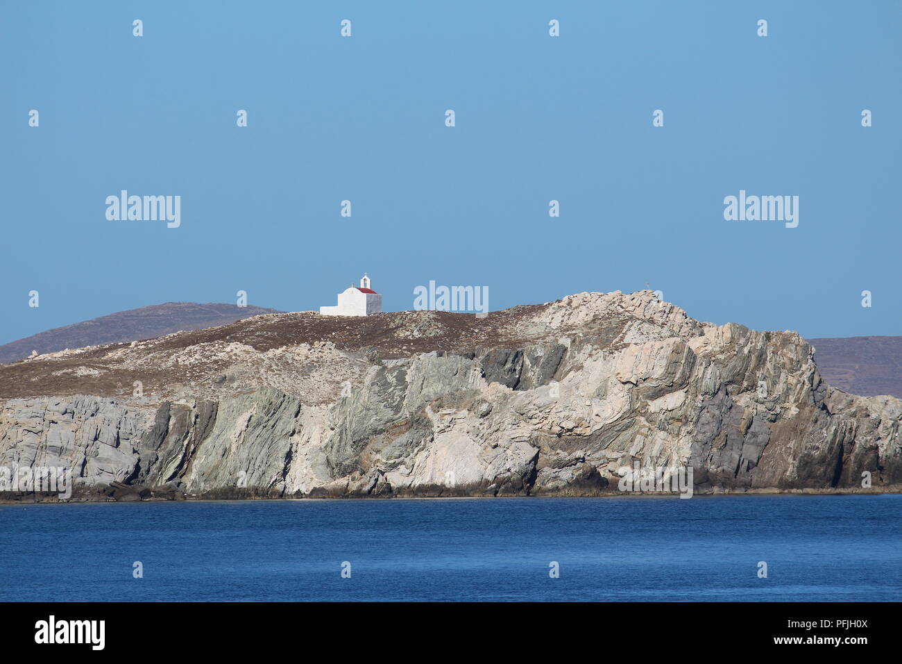 Little white church on rocky cliffs on the island of Mykonos Greece Stock Photo