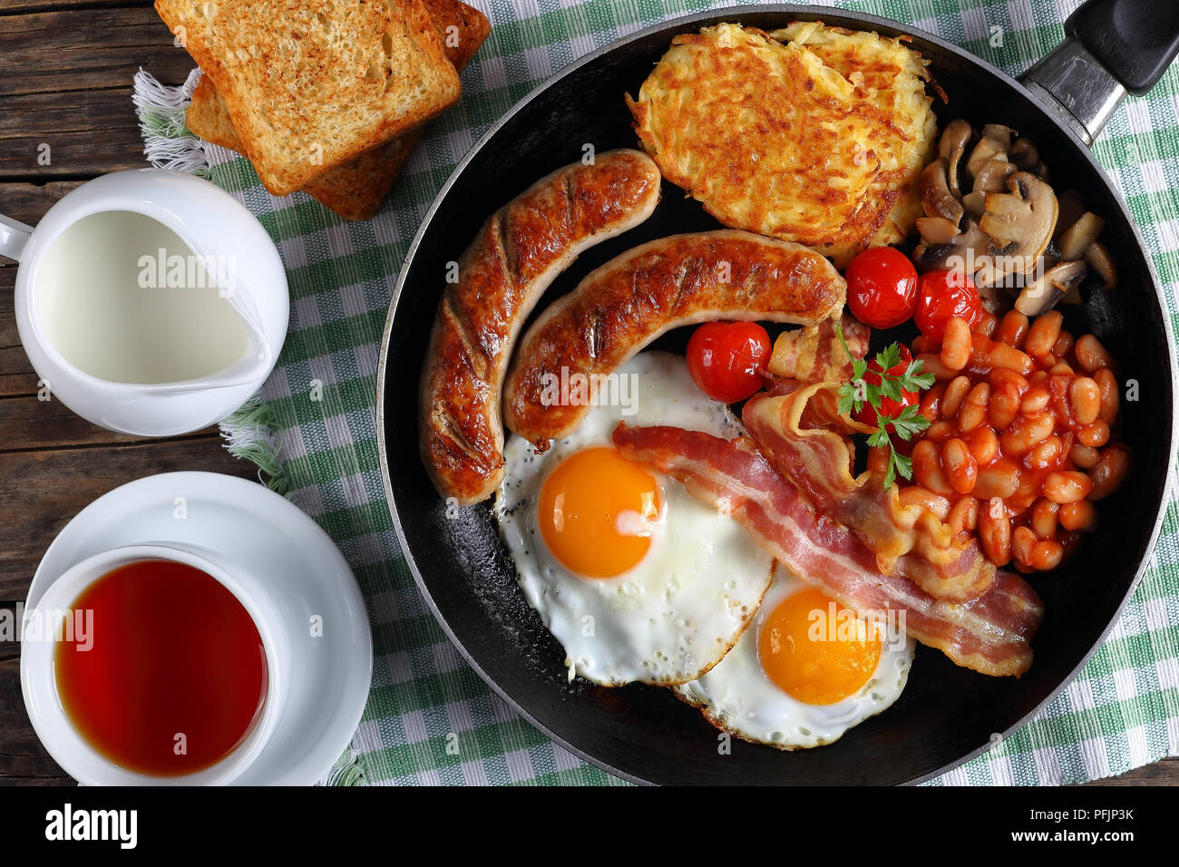 closeup of full english breakfast bean, hash brown, fried eggs