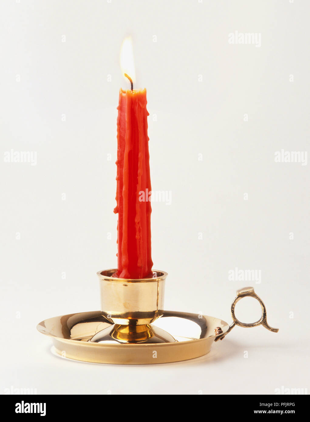 Lit red candle on a candlestick holder Stock Photo