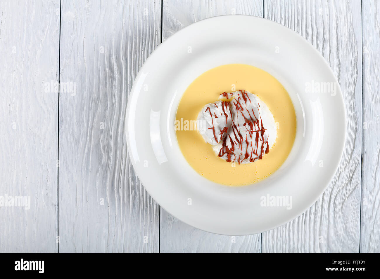 elegant french dessert  - a floating island is a dessert of French origin, consisting of meringue floating on creme anglaise or vanilla custard Stock Photo