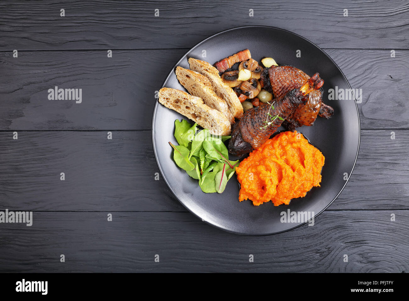 a portion of Coq Au Vin classic French chicken stew served on black