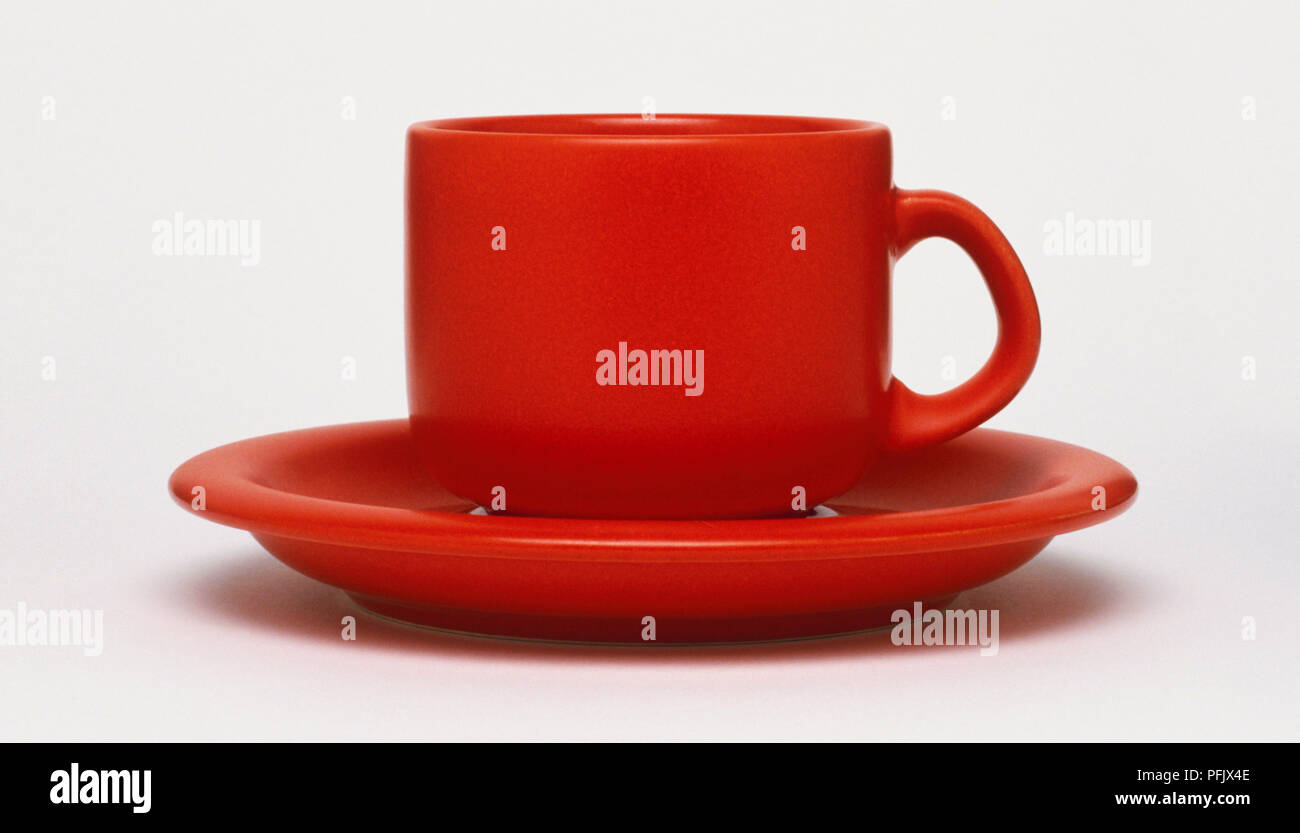Red coffee mug on matching saucer Stock Photo
