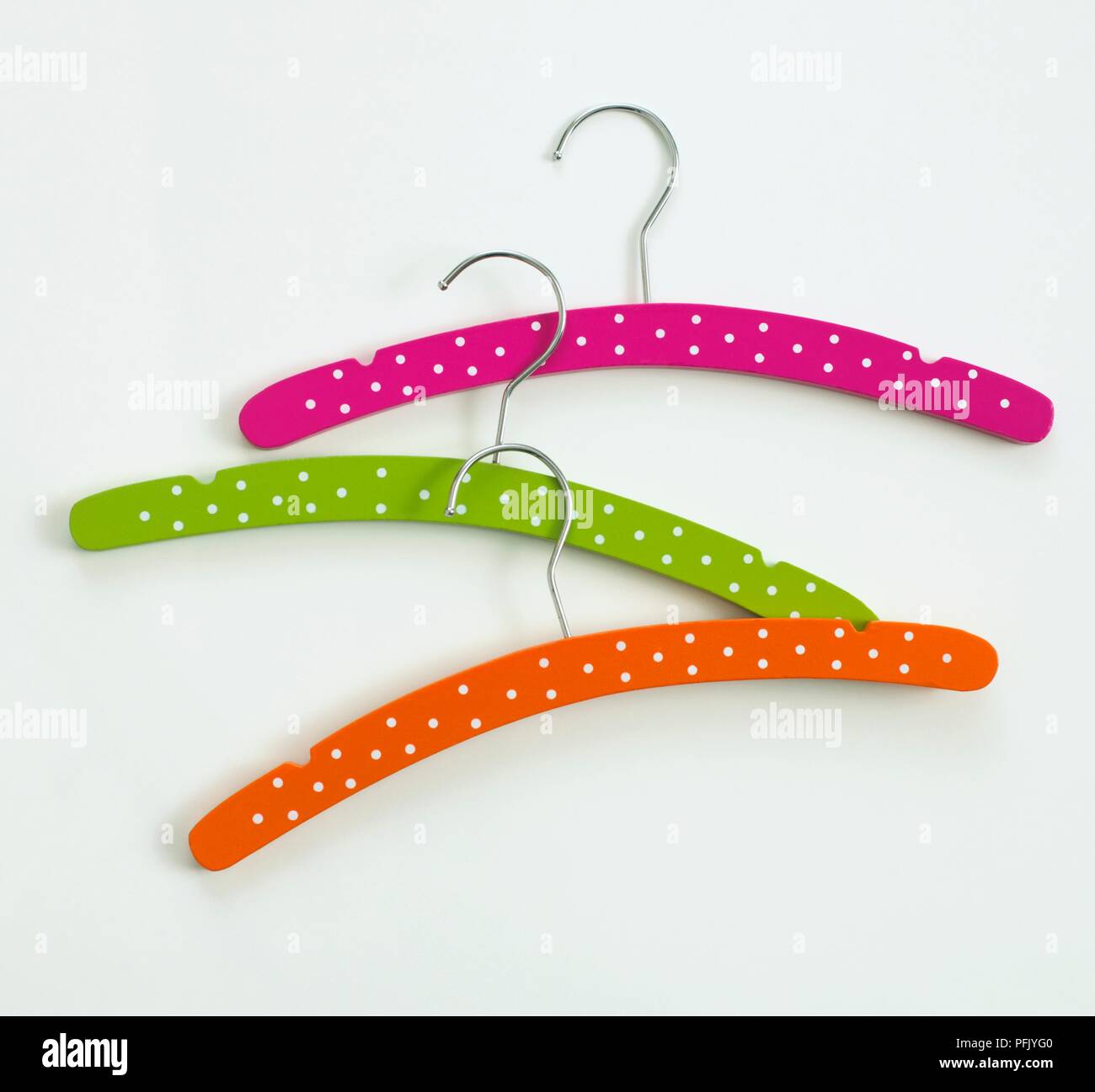 Three multi-coloured coat hangers with polka dots on them Stock Photo