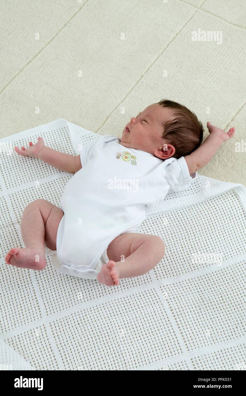 Swaddling a baby boy in a cellular blanket Stock Photo