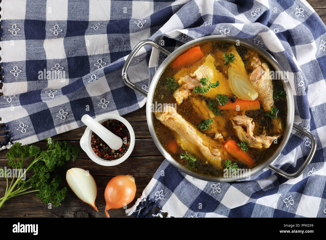 clear Chicken broth with pieces of hen and rooster meat on bone in a