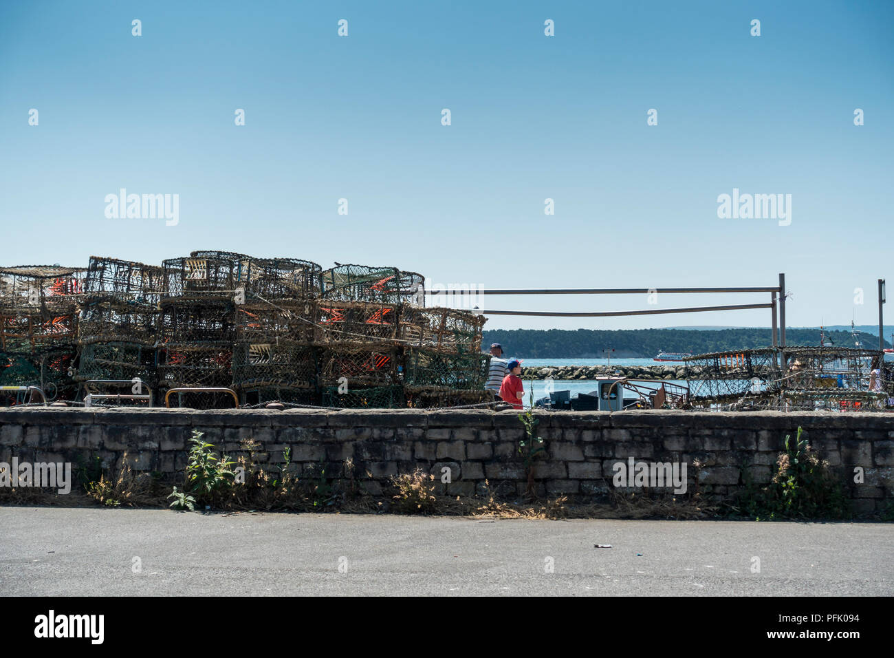 Crab and lobster pots stacked on the quay beside Poole Harbour, with a