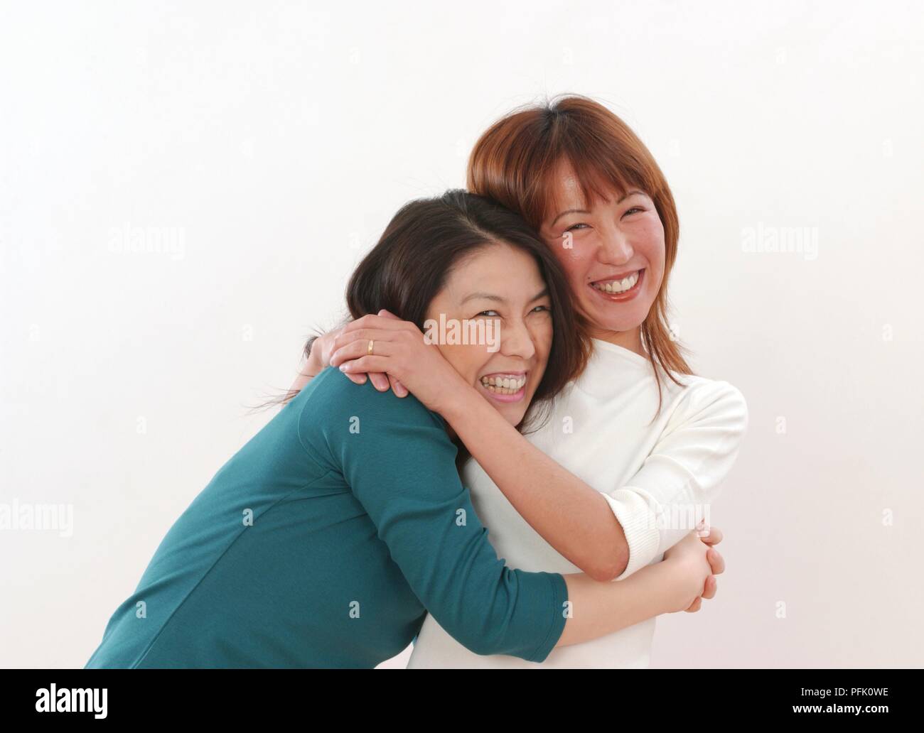 Two smiling women hugging Stock Photo - Alamy
