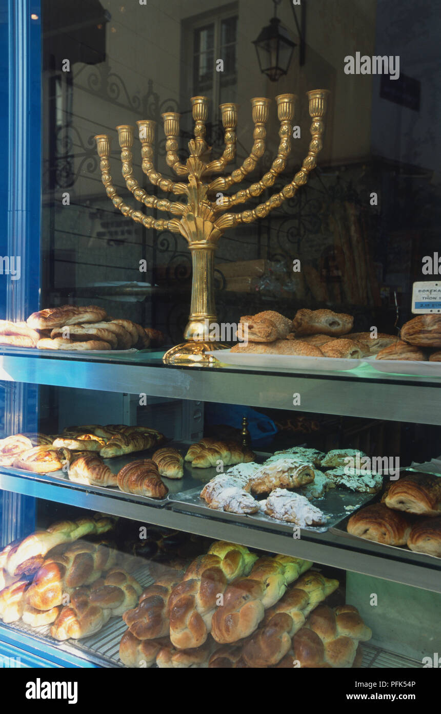 France, Paris, window of Jewish bakery, three shelves containing selection of baked goods, gold