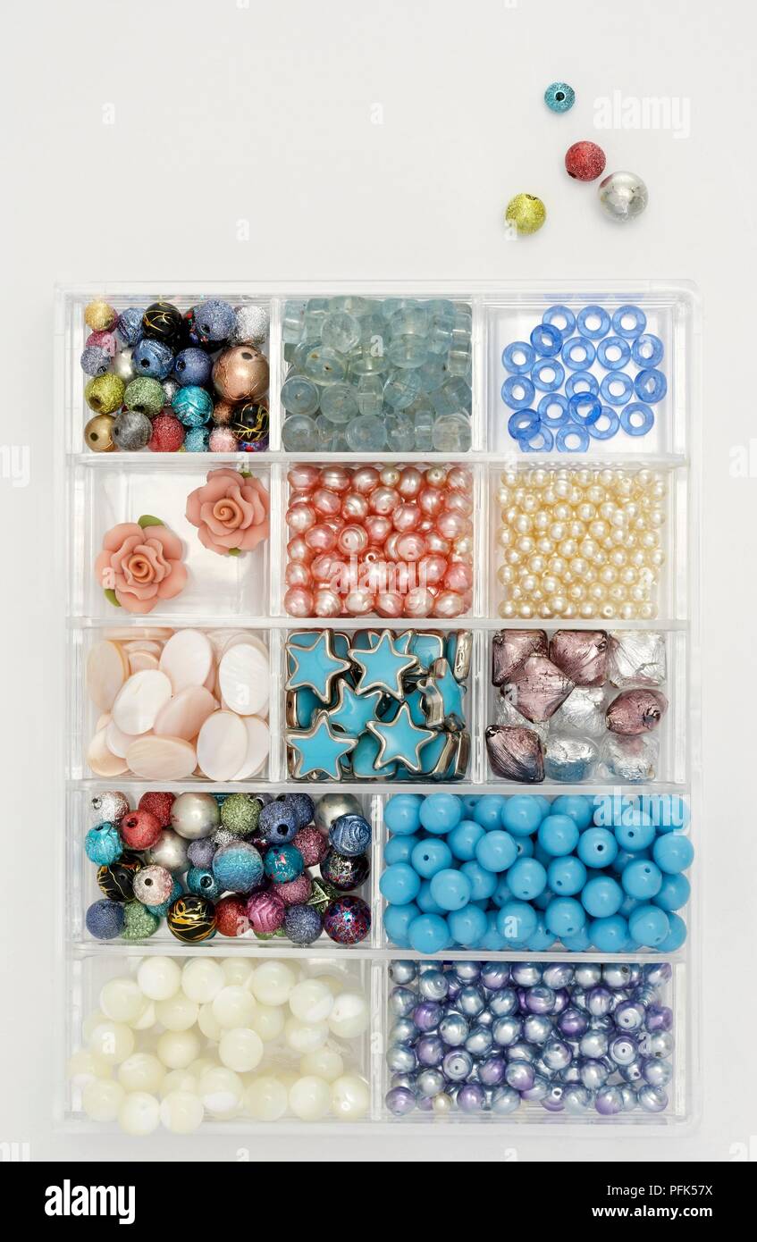 Bead box containing wide variety of differently shaped and coloured beads, including star and flower shapes Stock Photo