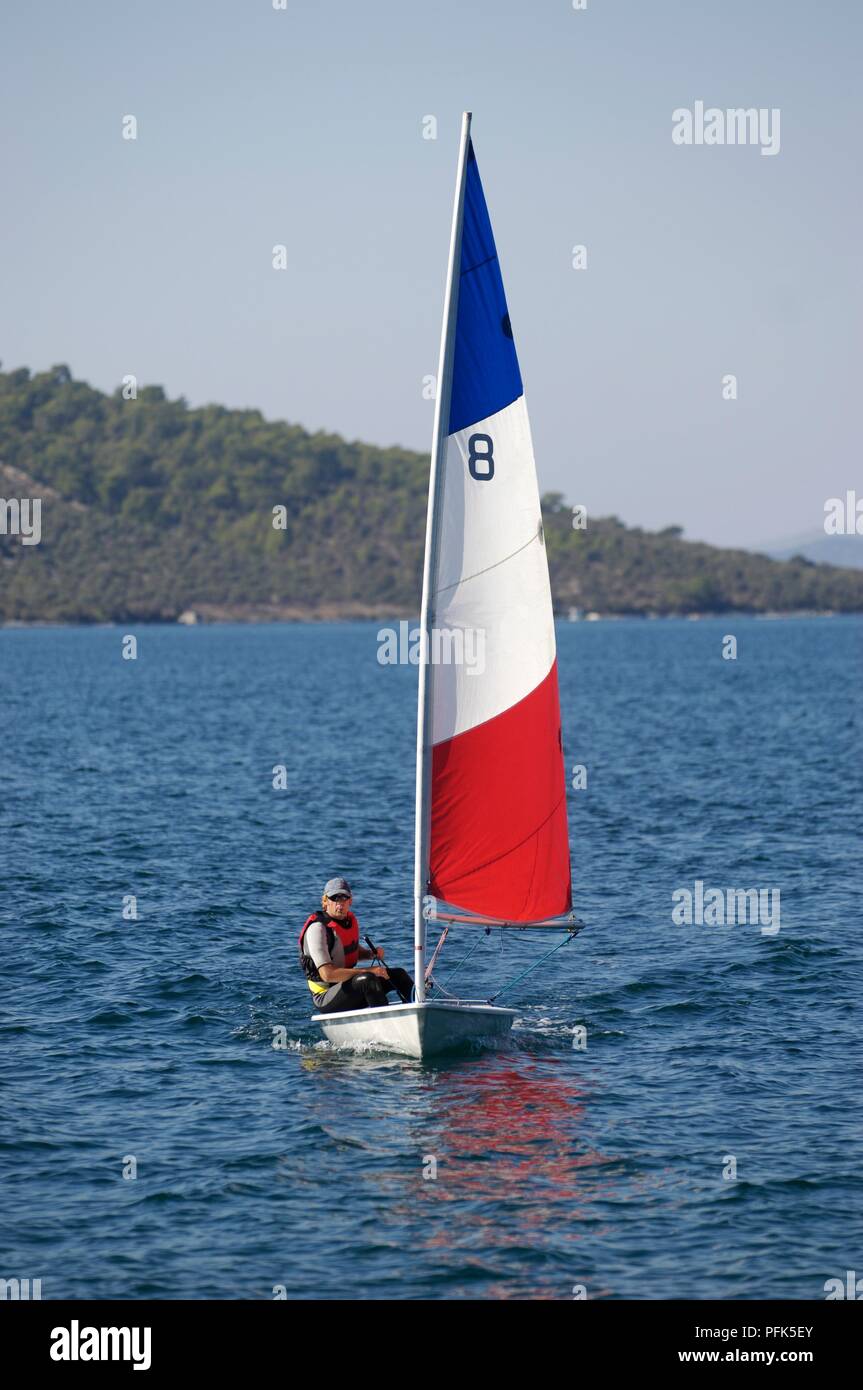 Turkey, young man wearing life jacket, sailing Laser class dinghy Stock