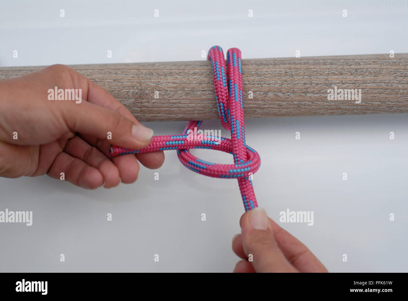 Hands tying rope around wood Stock Photo - Alamy