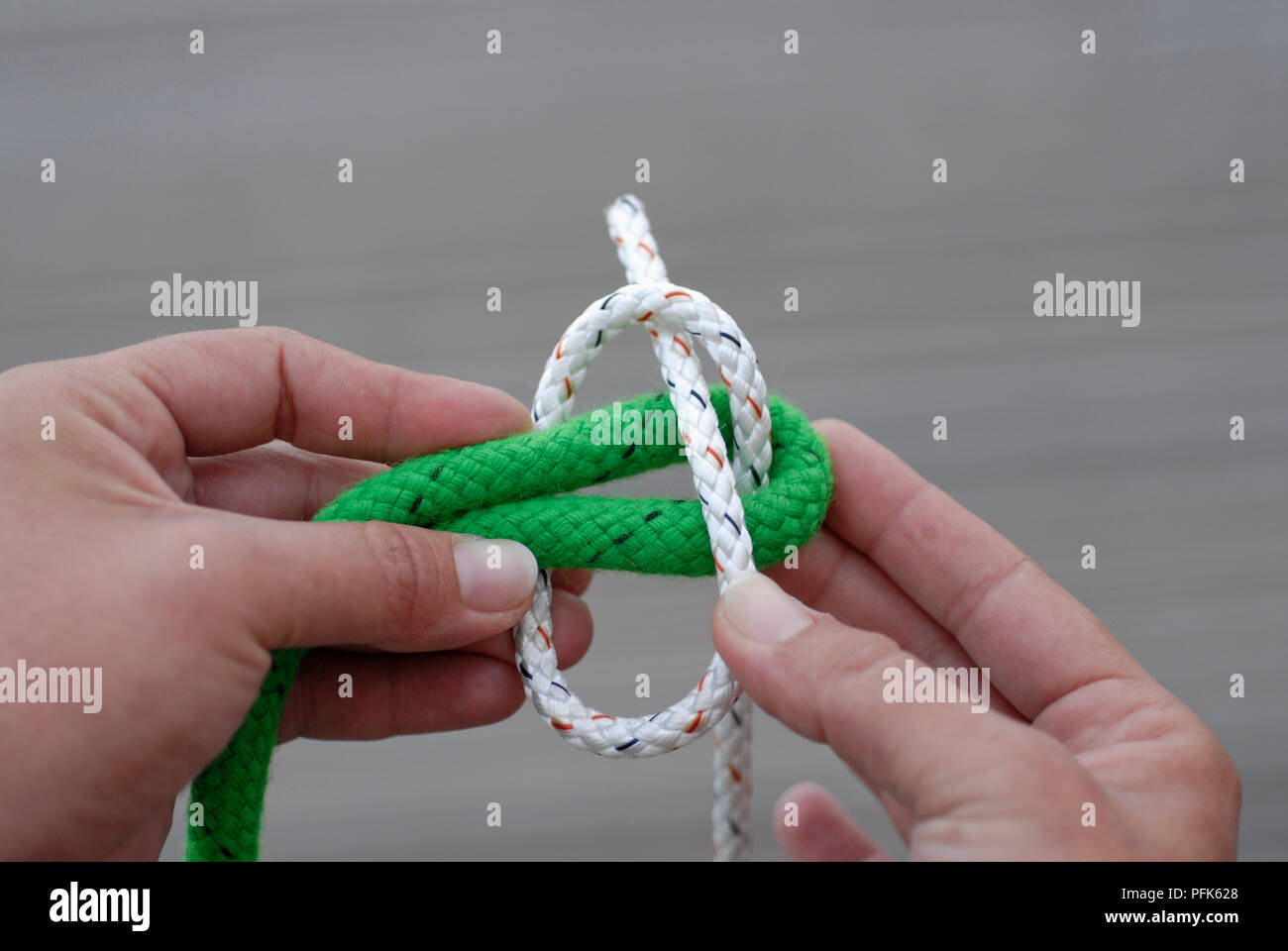 Hands tying knot around rope Stock Photo Alamy