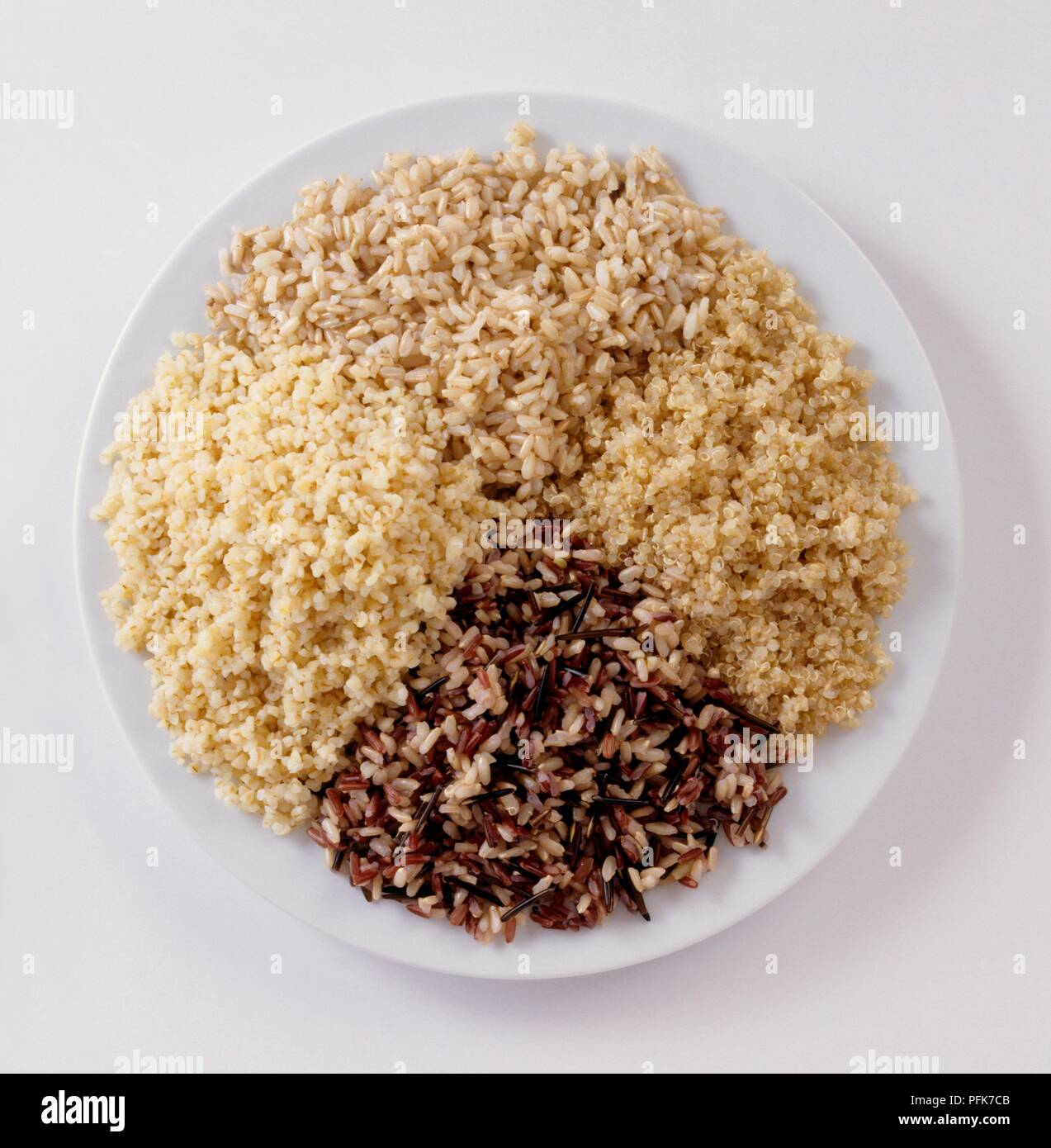 Heaps of boiled wild rice, bulgur wheat, quinoa and brown rice on plate
