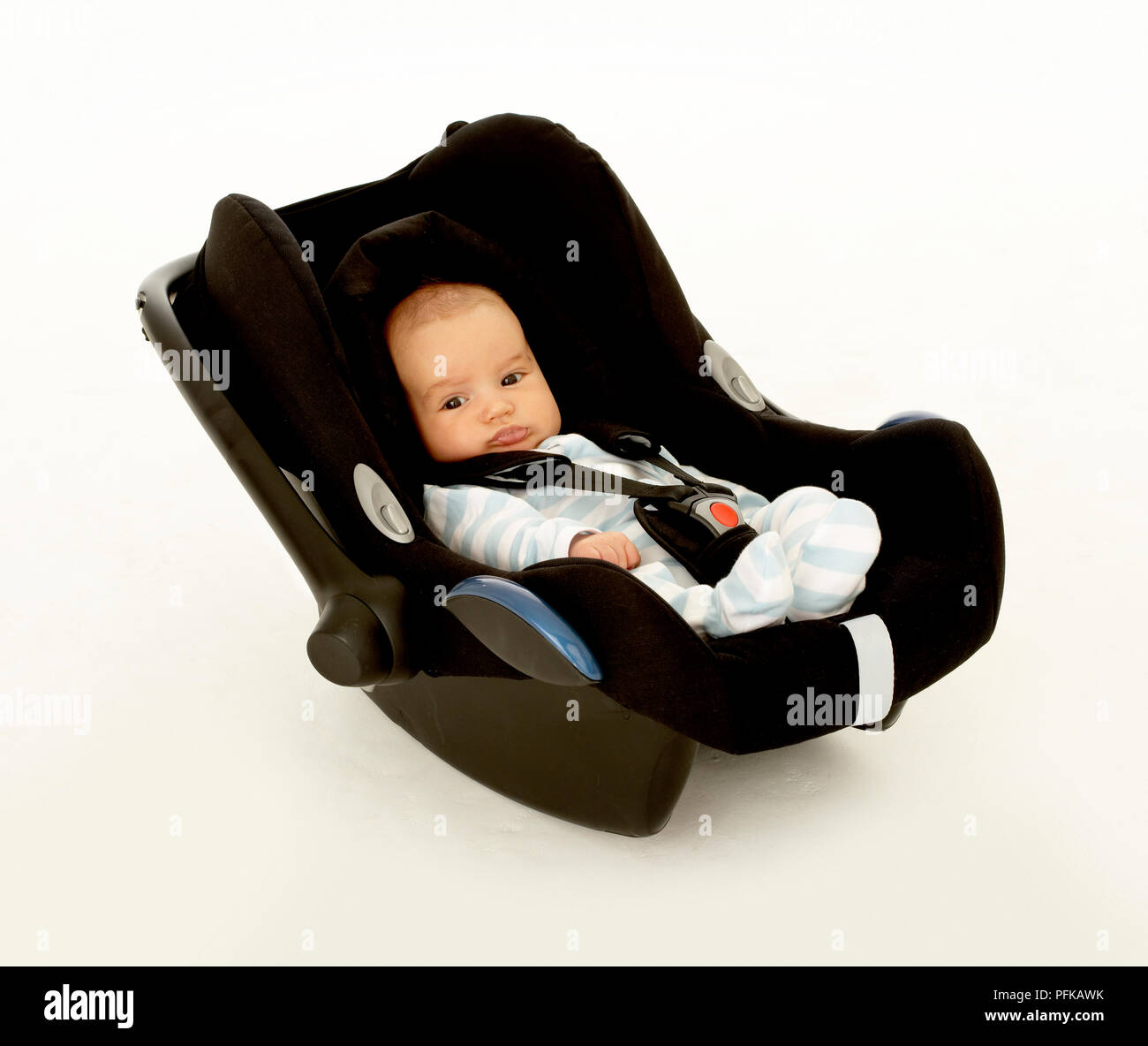 Baby boy strapped in seat Stock Photo