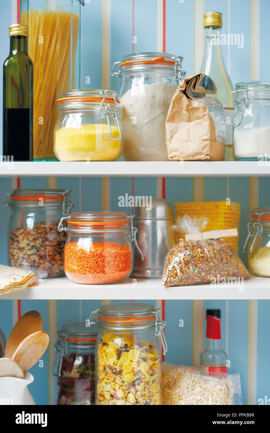 Bags, bottles and jars of food stored on shelves, including olive oil