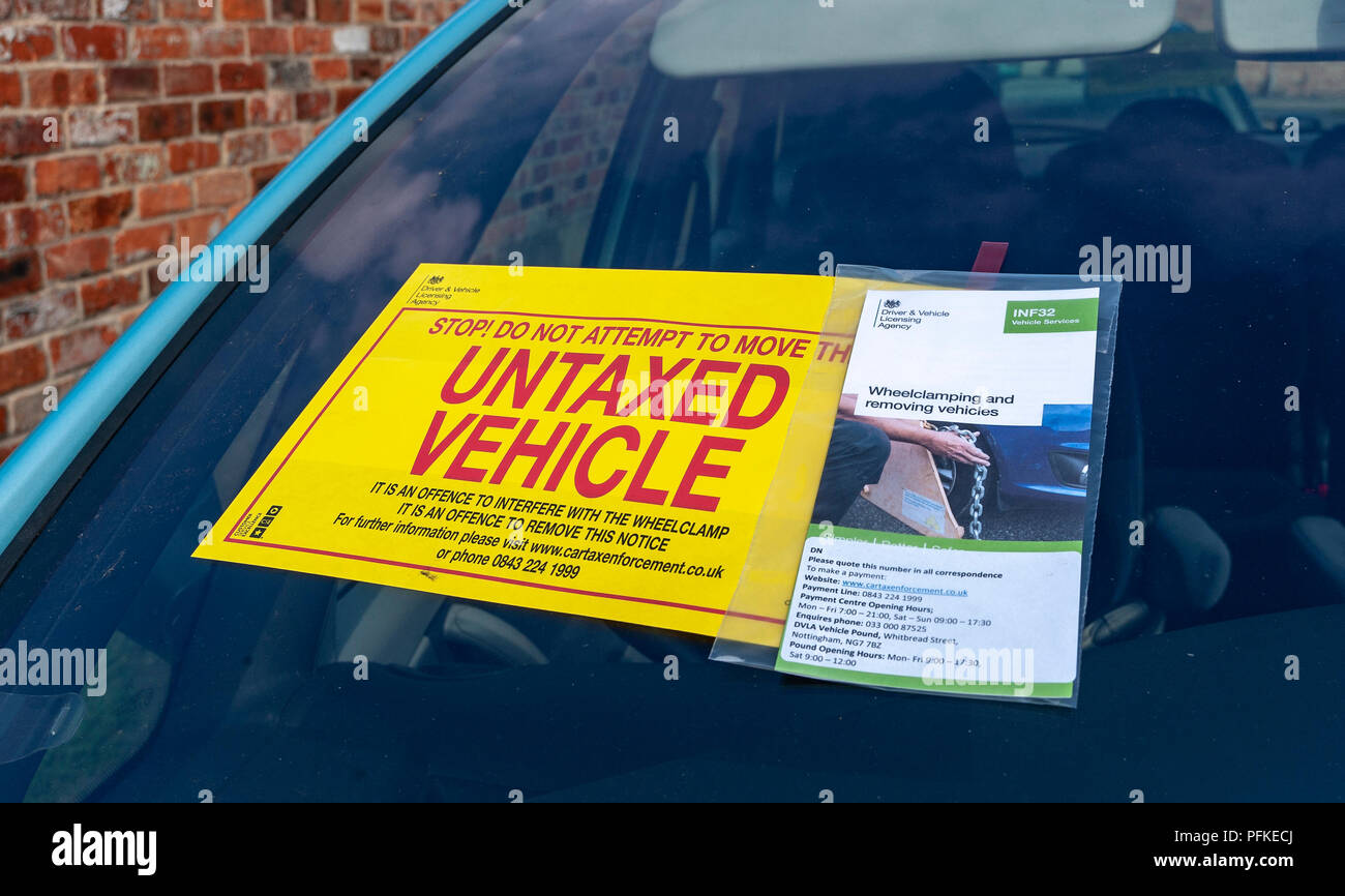 A Untaxed Vehicle notice stuck on the windscreen of an untaxed car Stock Photo