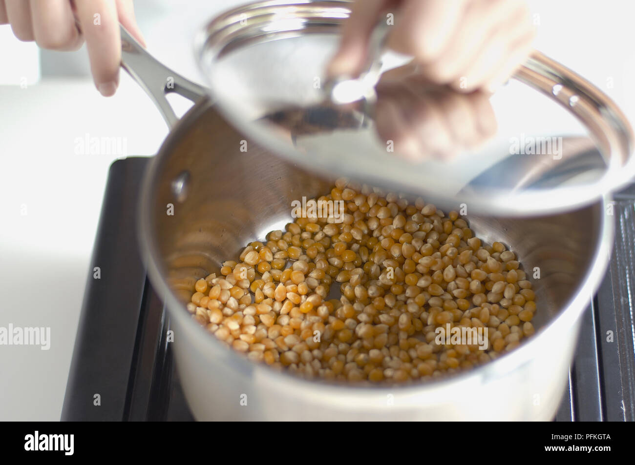 Removing lid of saucepan containing sweetcorn Stock Photo Alamy