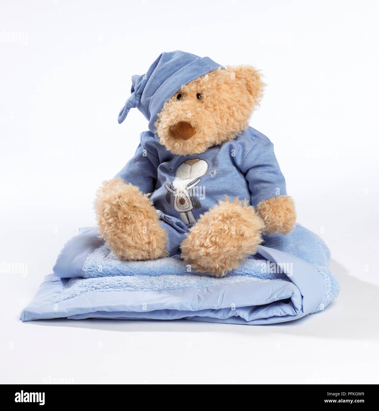 Teddy in pyjamas on baby blanket Stock Photo