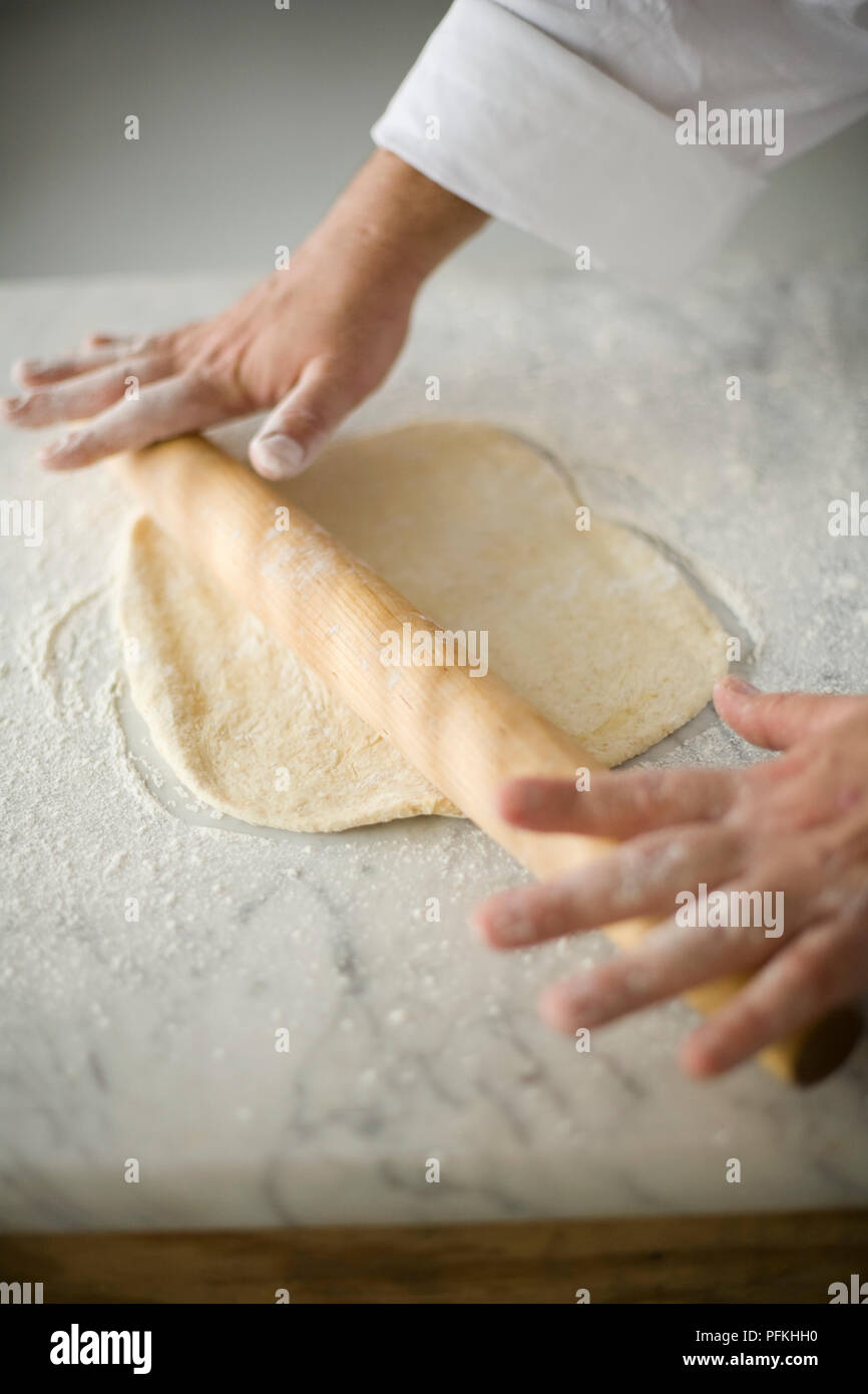 Hand rolling out pizza dough with rolling pin, closeup Stock Photo Alamy