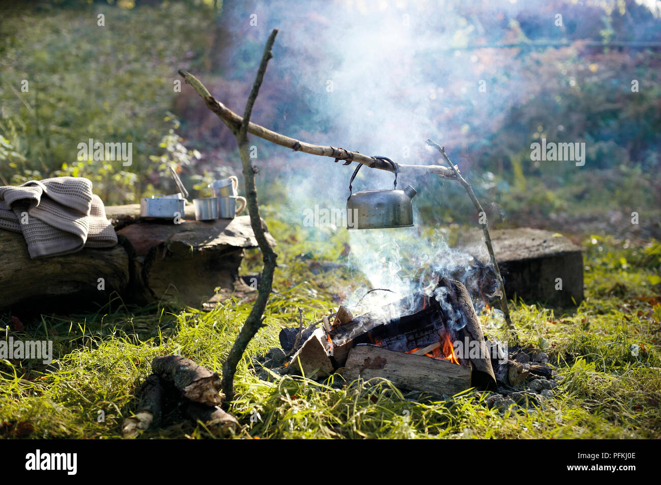 https://c8.alamy.com/comp/PFKJ0E/kettle-hanging-from-branch-frame-by-handle-above-burning-camp-fire-on-grass-PFKJ0E.jpg