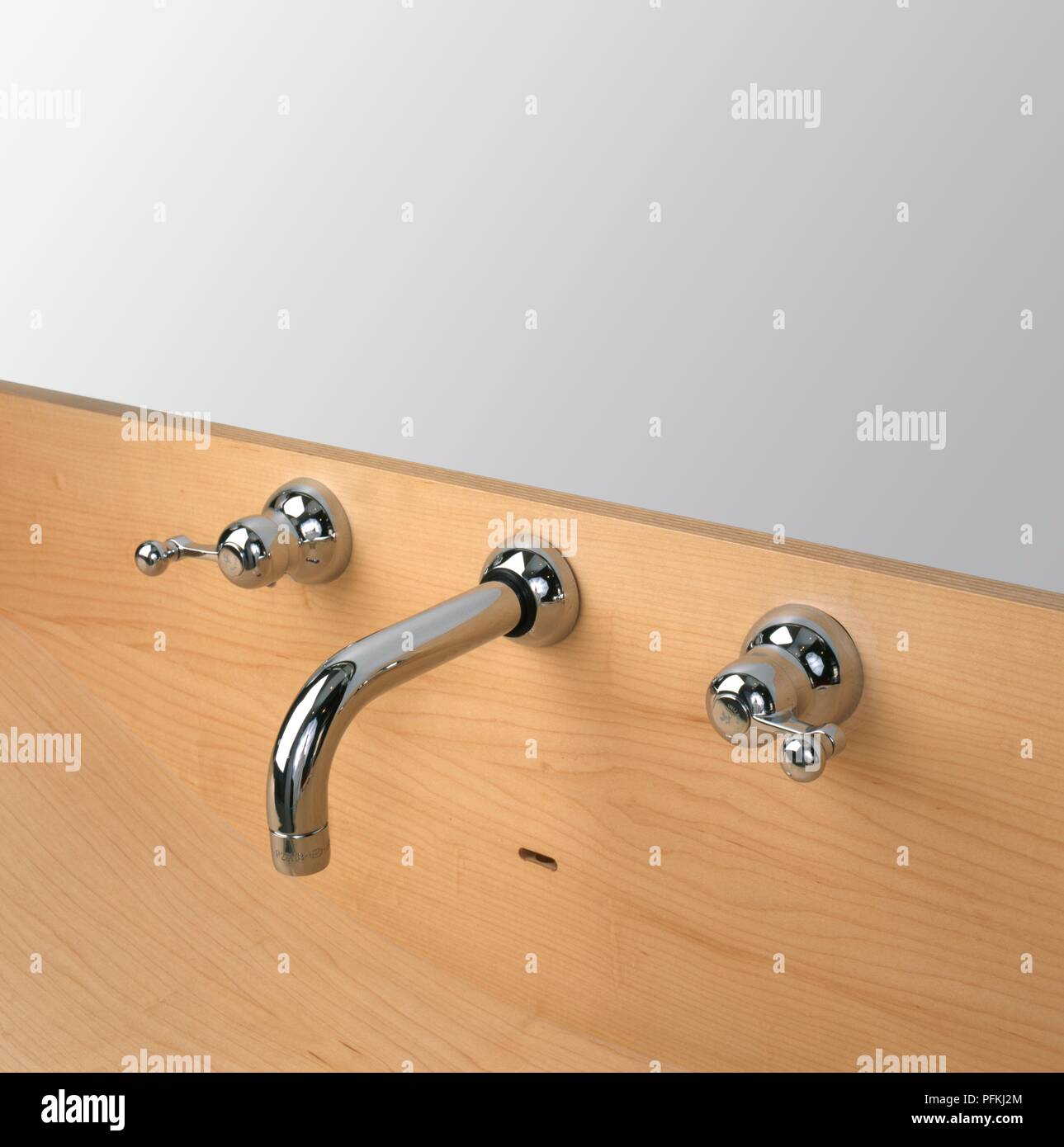 Bathroom tap fittings set in wooden surface, close-up Stock Photo