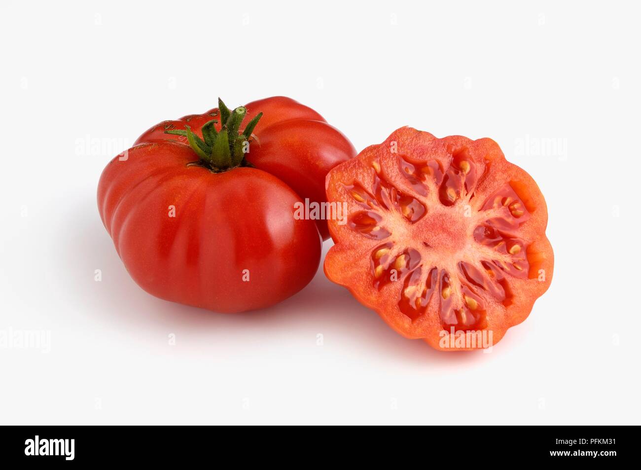 Whole and sliced Italian Costoluto Fiorentino tomatoes Stock Photo