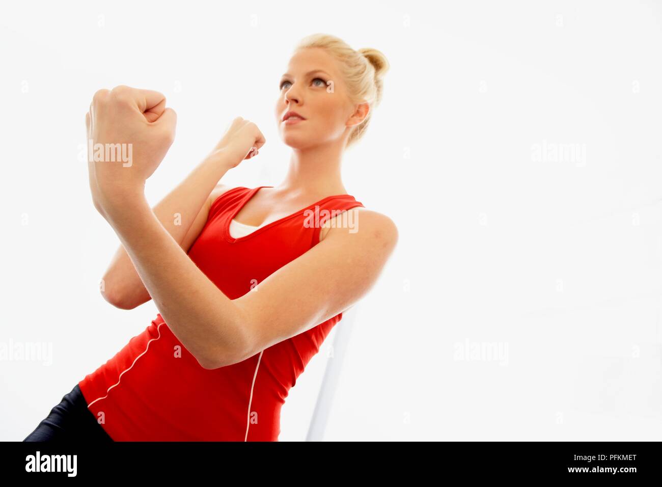 Young woman performing boxing exercise with clenched fists Stock Photo