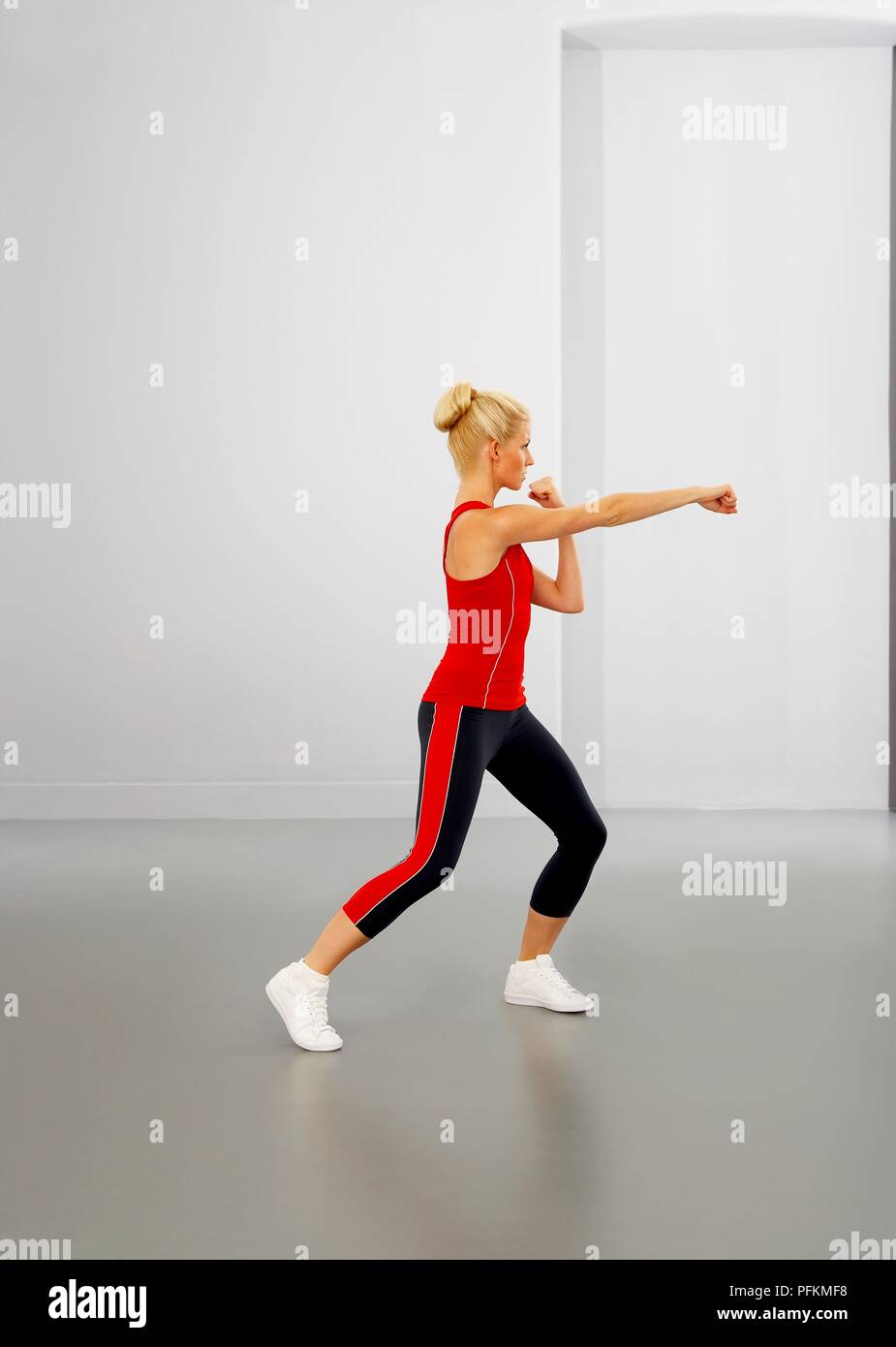 Young woman performing boxing exercise with clenched fists Stock Photo