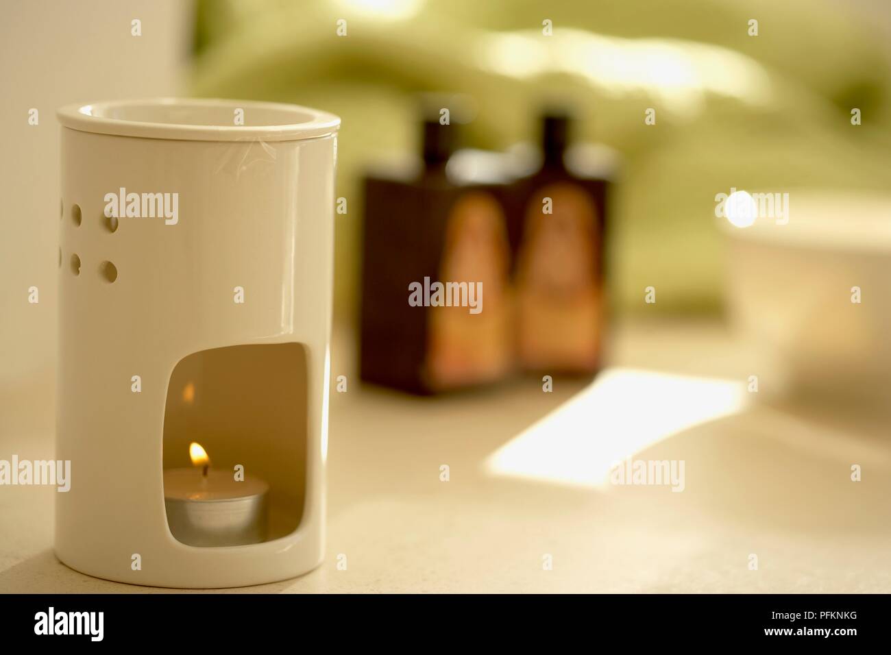 Tea light burning in oil burner Stock Photo Alamy