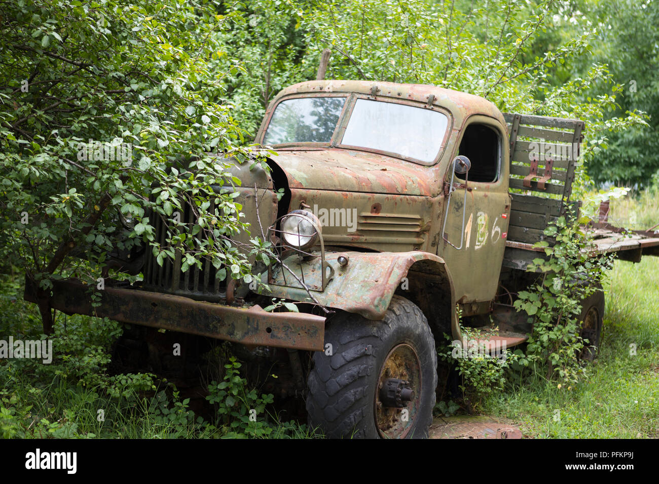 Abandoned Russian army truck parked against trees in Bulgaria Stock Photo
