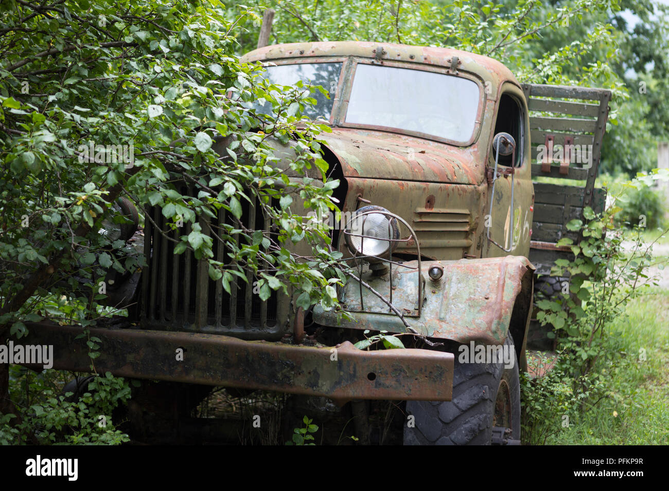 Abandoned Russian army truck parked against trees in Bulgaria Stock Photo