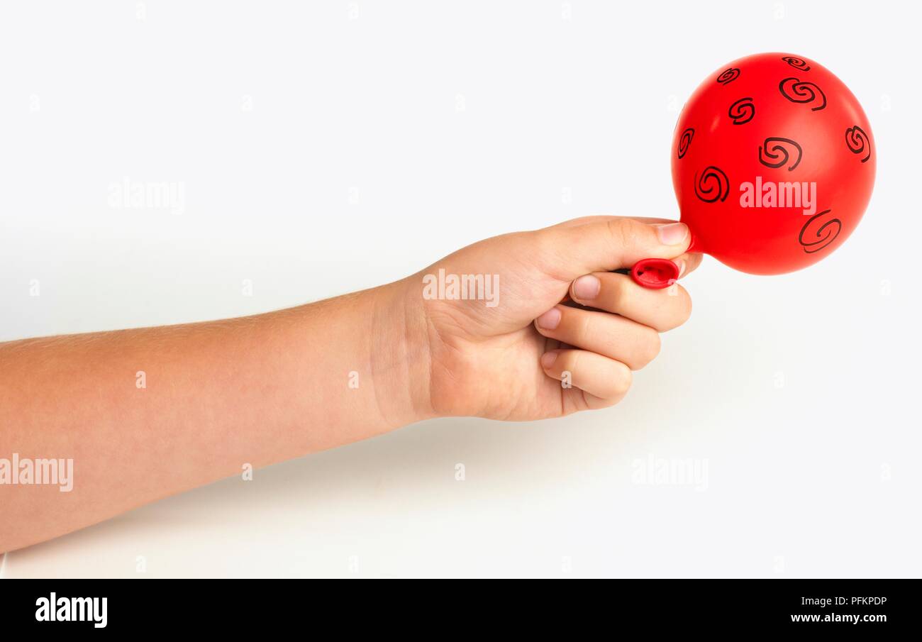 Child's hand holding partially inflated red balloon with swirly pattern on,  close-up Stock Photo - Alamy