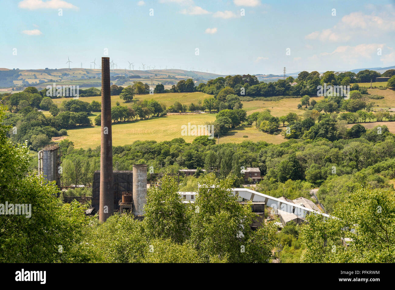 Derelict buildings  and chimney stack on the site of the former Cwm colliery and coke ovens in Beddau near Pontypridd, Wales. Stock Photo