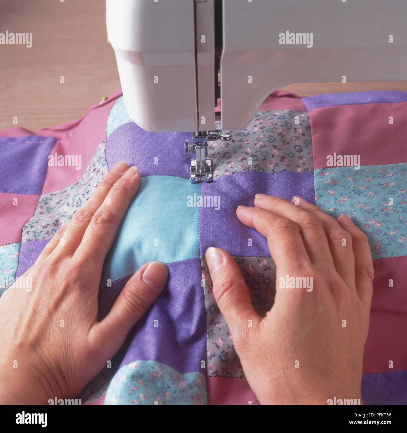 Quilted fabric being sewn along seam lines, using sewing machine Stock Photo Alamy