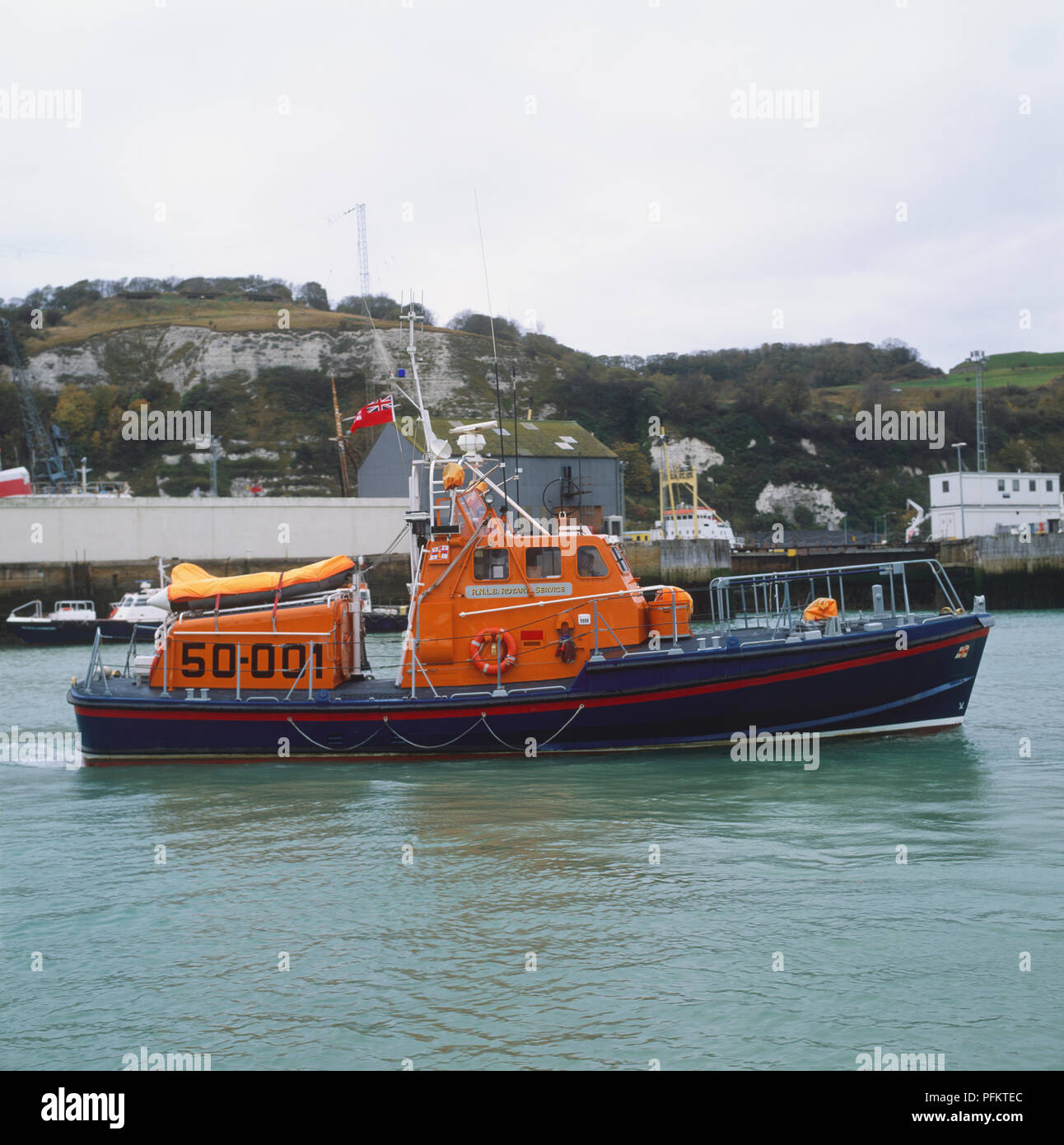 British orange and blue rescue boat sailing on water. Stock Photo