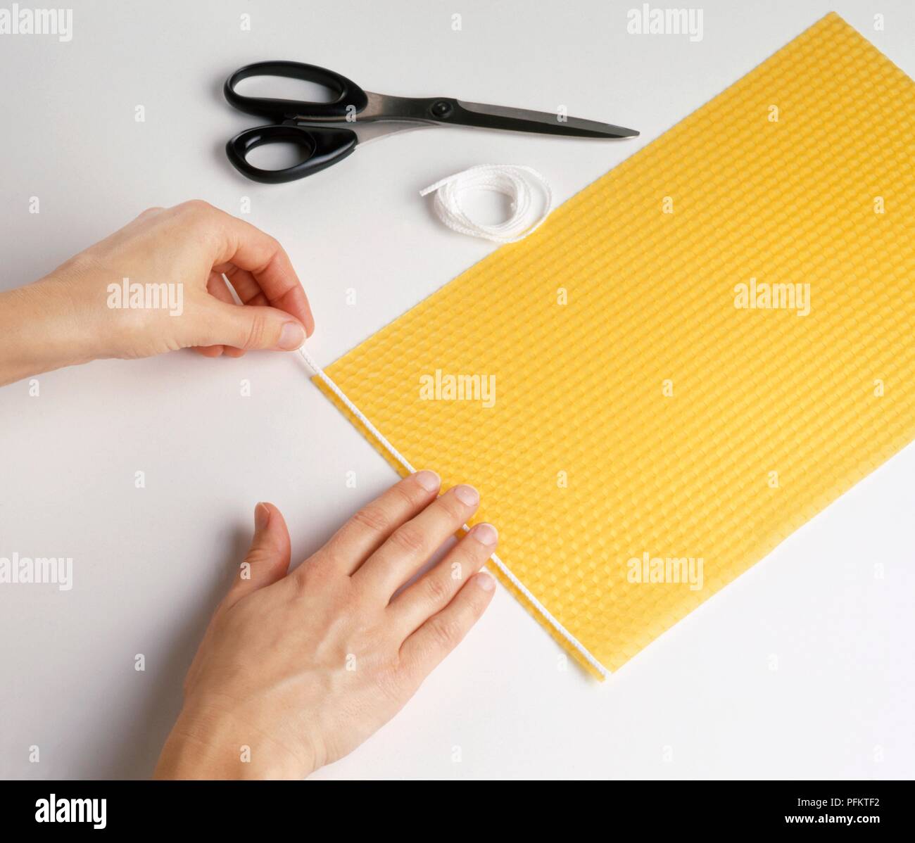 Making rolled beeswax candle by adding string Stock Photo - Alamy