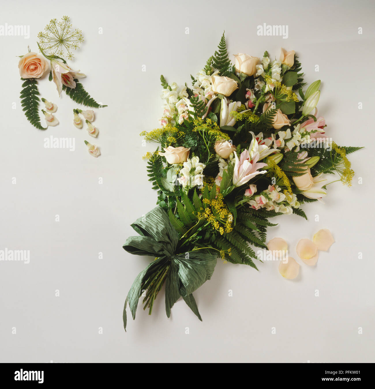 A bouquet of peach flowers including Snapdragons, Lilies, Roses, yellow Fennel and green Bracken. Stock Photo