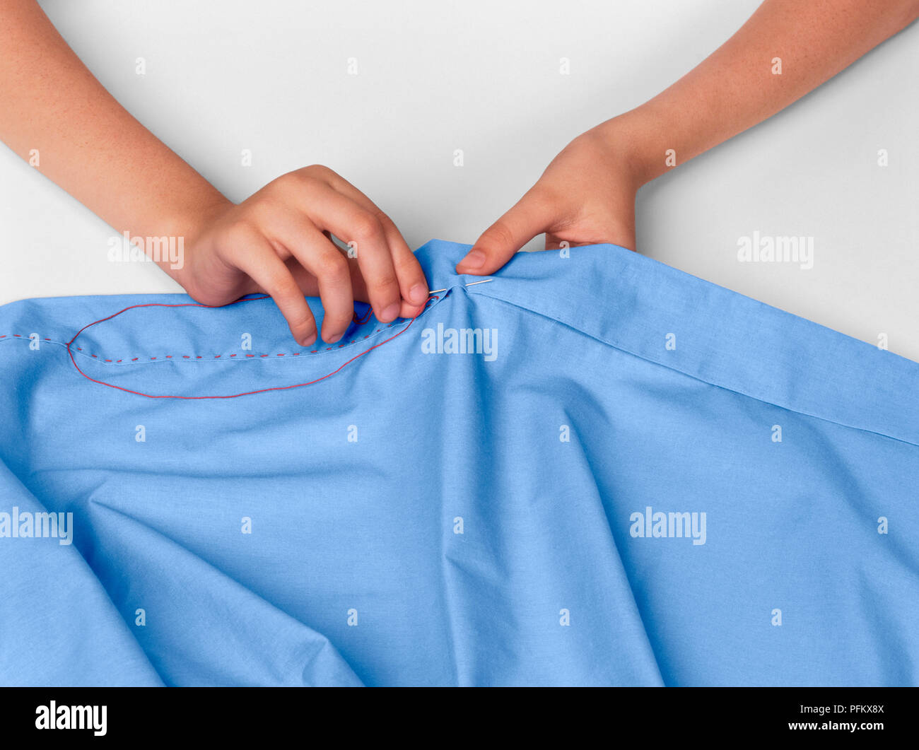 Using needle and thread to sew running stitch or straight stitch on hem