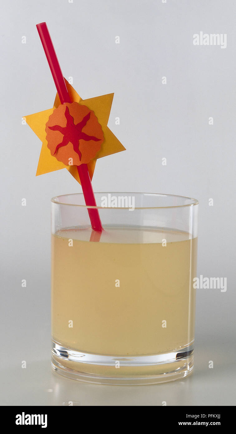 Glass tumbler containing real lemonade. A red plastic staw with a simple card star decoration attached to it. Stock Photo