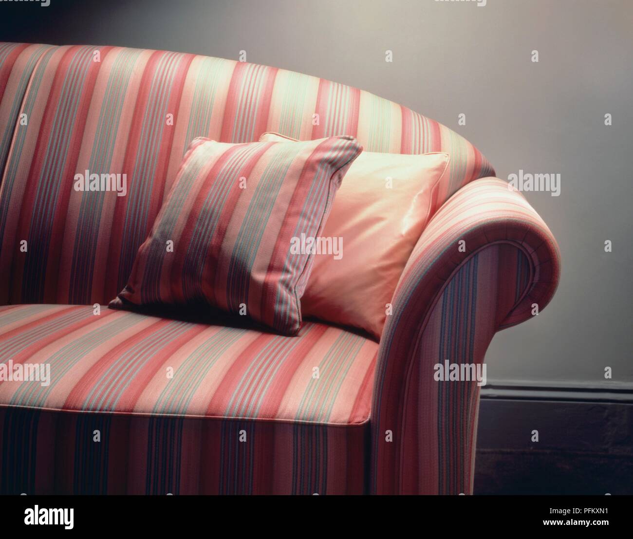 Sofa covered with pink Regency stripe fabric and matching cushions