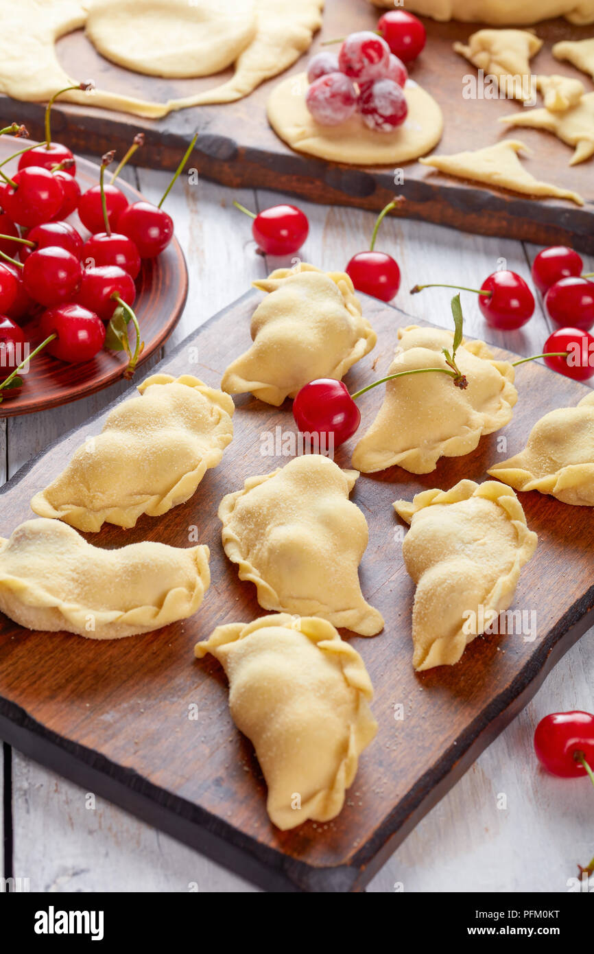 Uncooked Cherry Dumplings On A Wooden Table With Dough Rolling Pin And Plate With Fresh Cherries At The Background Close Up Vertical View From Abov Stock Photo Alamy