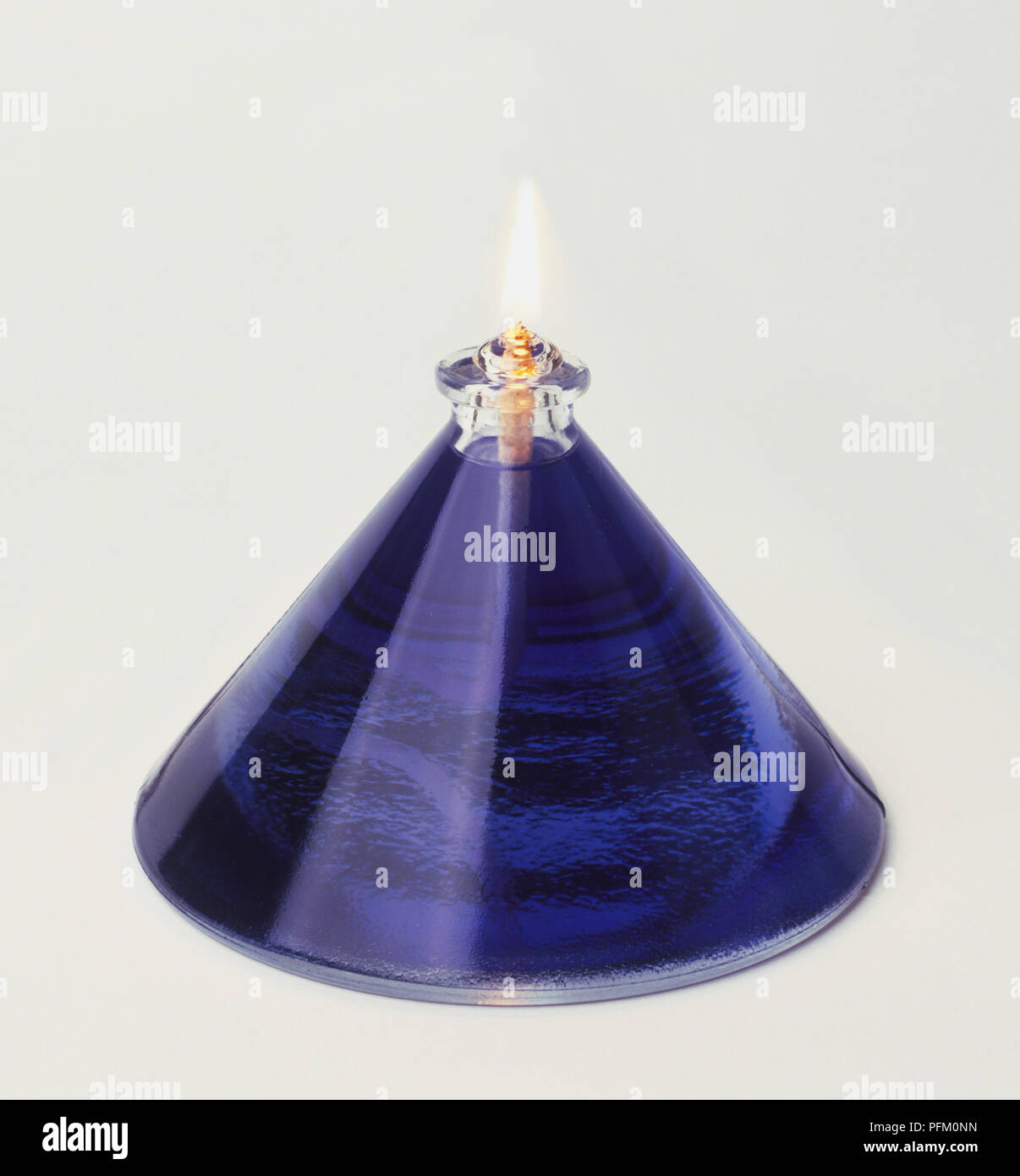 Glass oil burner full of blue liquid Stock Photo