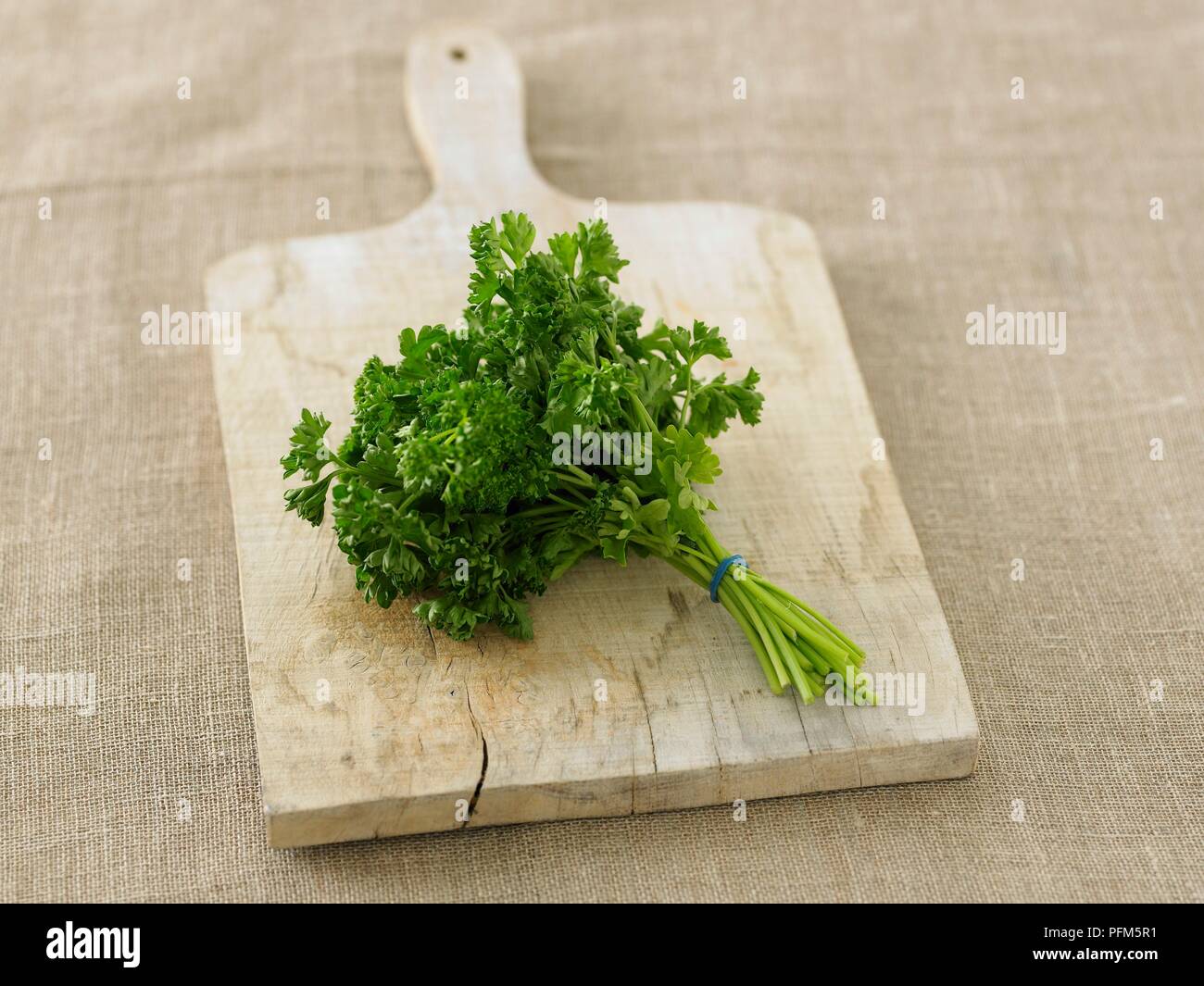 Bunch of parsley on chopping board Stock Photo