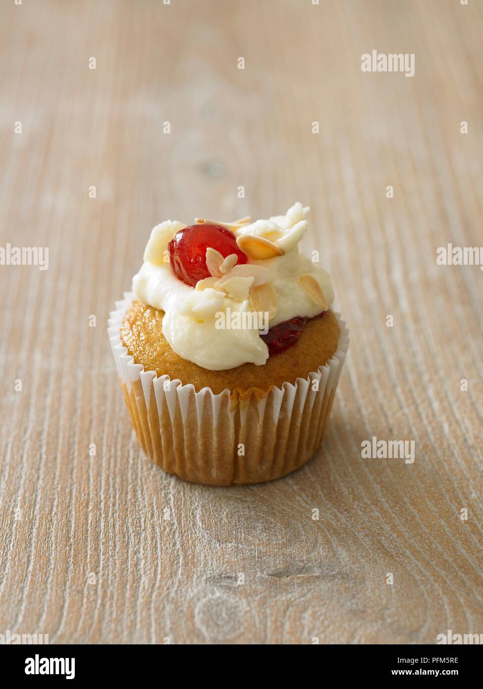 Sponge cupcake with icing and cherry on top Stock Photo