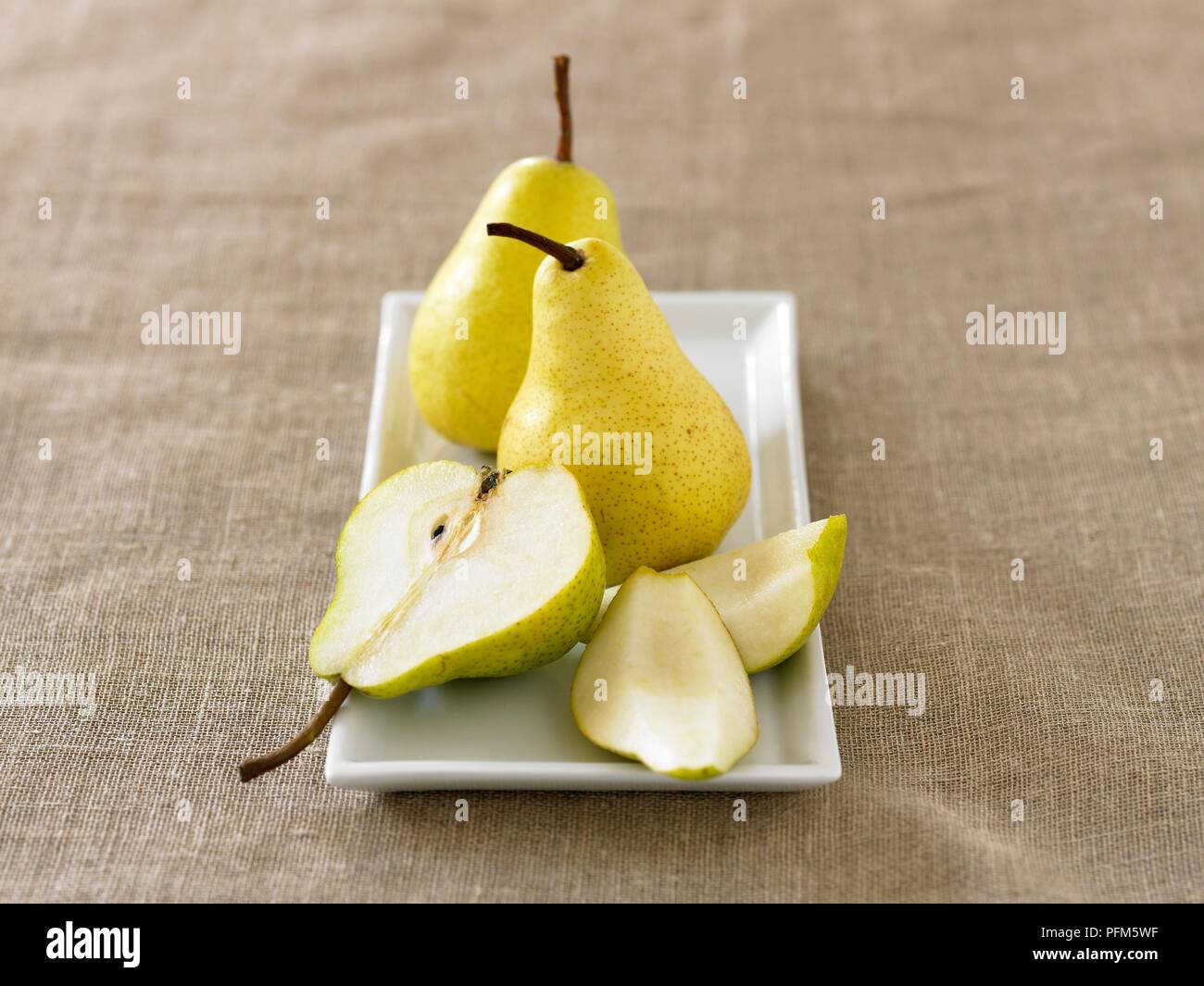 Pears whole and sliced on a rectangular plate Stock Photo