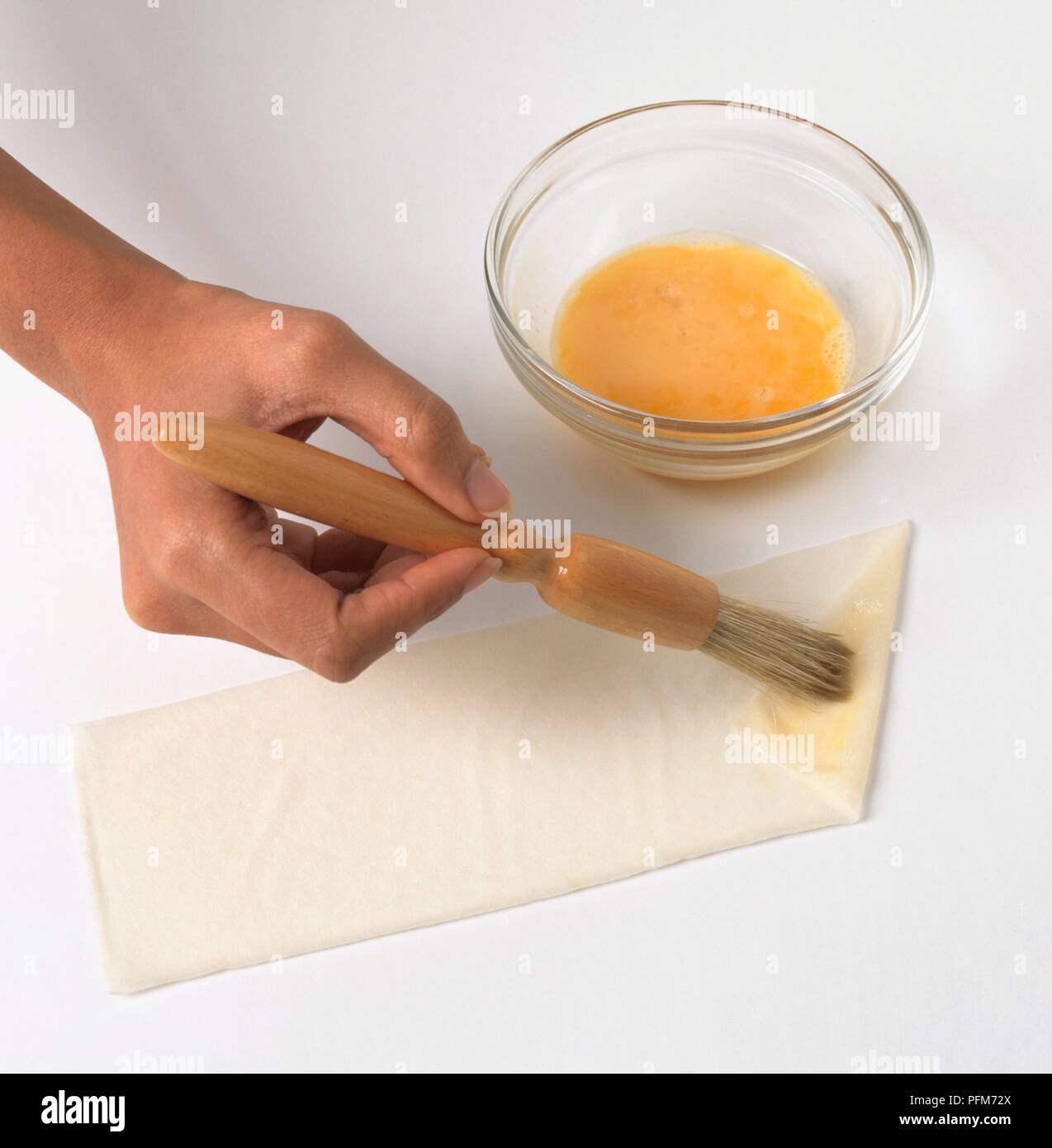 Brushing egg yolk on folded edge of samosa pastry Stock Photo Alamy