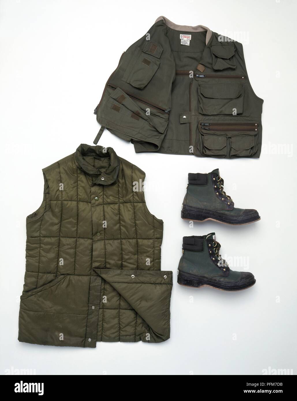 Clothing for fishing, including padded jacket, jacket with pockets, and boots Stock Photo