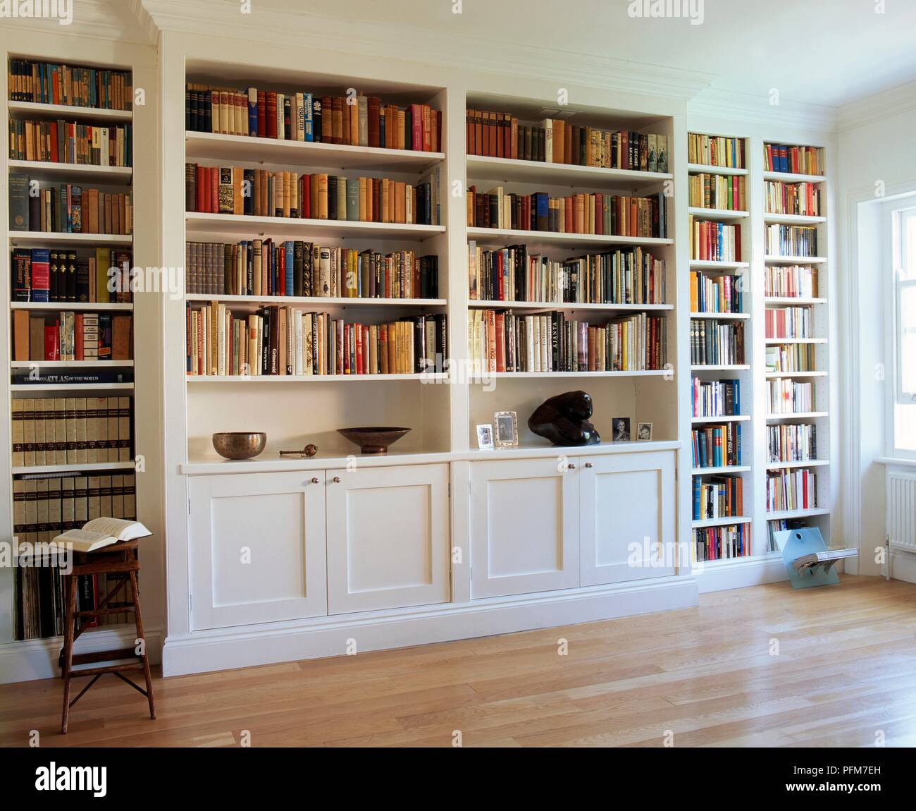 White, built-in bookcase filled with books Stock Photo - Alamy